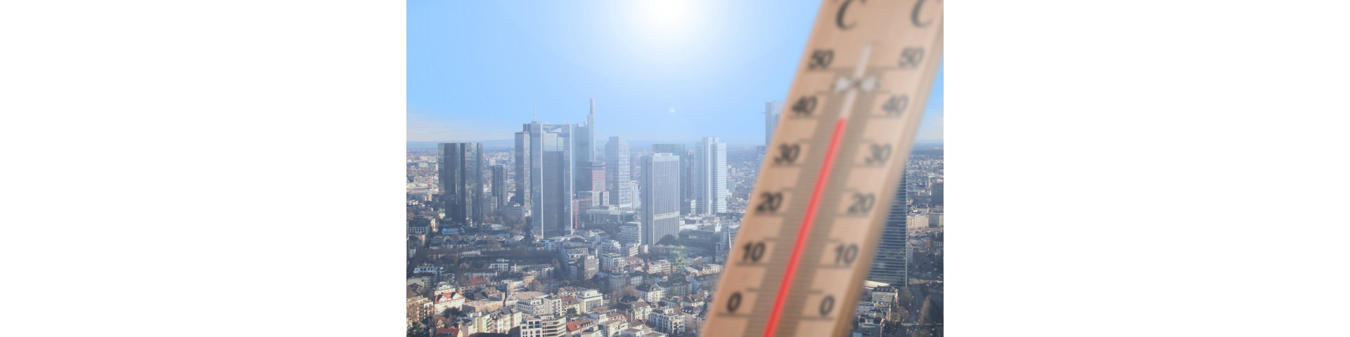 an image of themrometer with scorching sun and some buildings in the background